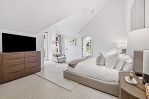 A bedroom with a large bed, a wooden dresser, and a television. - Solaris PHFW - 3 Bedroom + Den (Vail)
