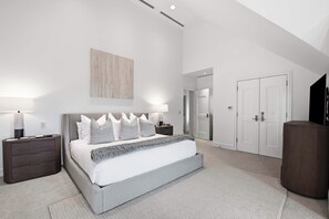 A modern bedroom with a large bed, bedside tables, a flat-screen TV, and a wardrobe. - Solaris PHFW - 3 Bedroom + Den (Vail)