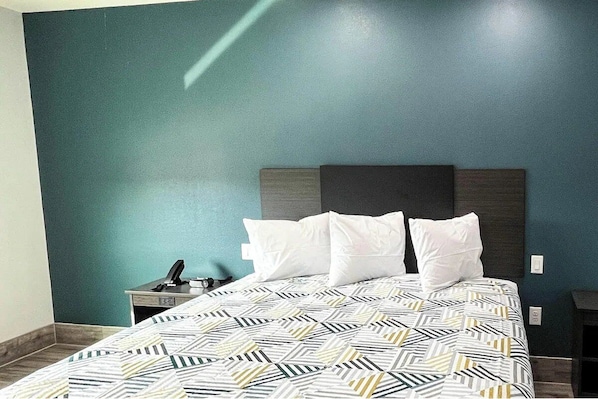 Ein Hotelzimmer mit Bett, Nachttisch und Schreibtisch.