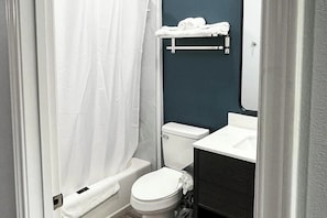 Ein Badezimmer mit Toilette, Badewanne, Waschbecken und Handtuchhalter.