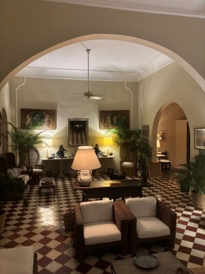 A hotel lobby with a checkered floor, arched ceiling, and a central seating area with lamps. - Historic Waterfront Villa with Dock, Private Pool and Caribbean Charm (Cartagena)
