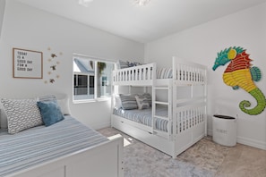 A child's bedroom with a bunk bed, a window, a wall decoration, and a trash bin. - Pearl Street Retreat (Fort Myers Beach)