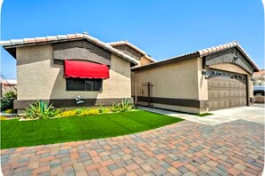 Ein Wohnhaus mit Garage, gepflegtem Rasen und befestigter Auffahrt.