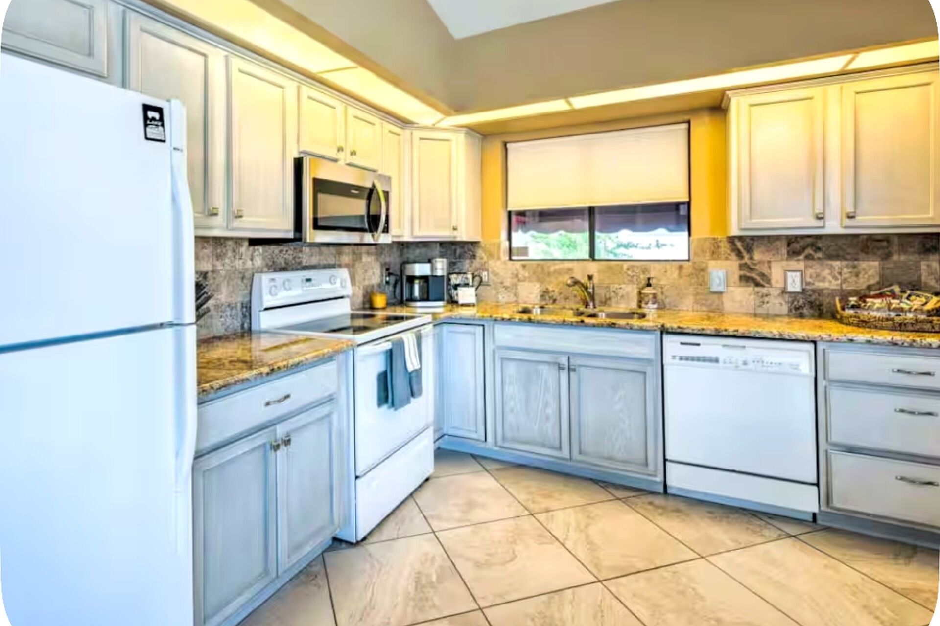A kitchen with white cabinets, a microwave, a stove, and a dishwasher.