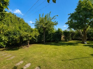 A well-maintained grassy area with trees and a clear sky. - Pogido Pet House (Arcos de Valdevez)