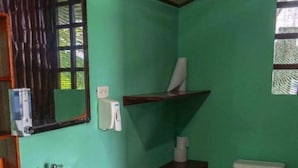 A bathroom with a sink, toilet, and a mirror. - Pacífic Corcovado Bumgalows - Deluxe Double or Twin Room with Ocean View (Agujitas (Drake))