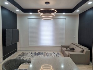 Una sala de estar moderna con un sofá, una mesa de centro y un televisor montado en la pared.