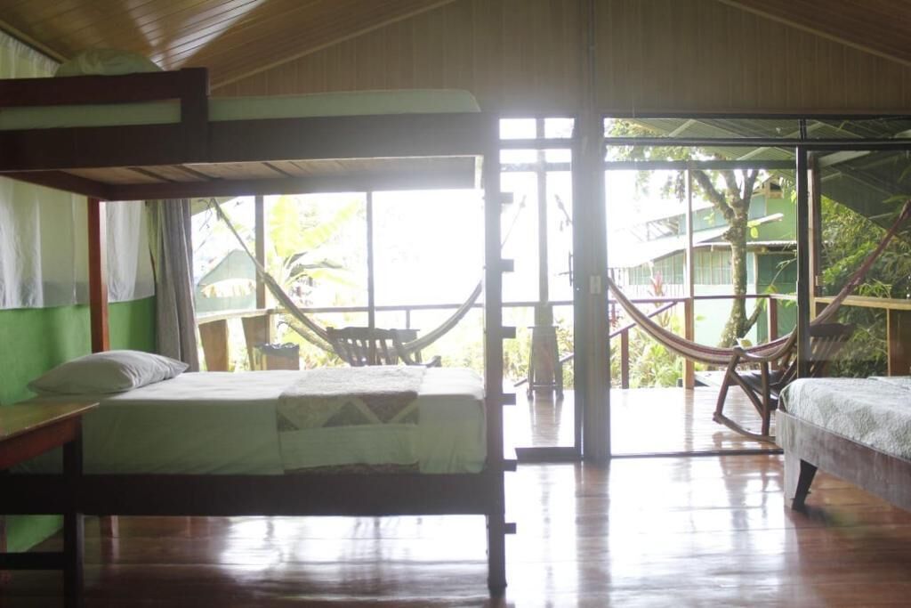 A room with a bed, a chair, and a hammock.