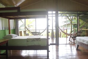 Una habitación con una cama, una silla y una hamaca.