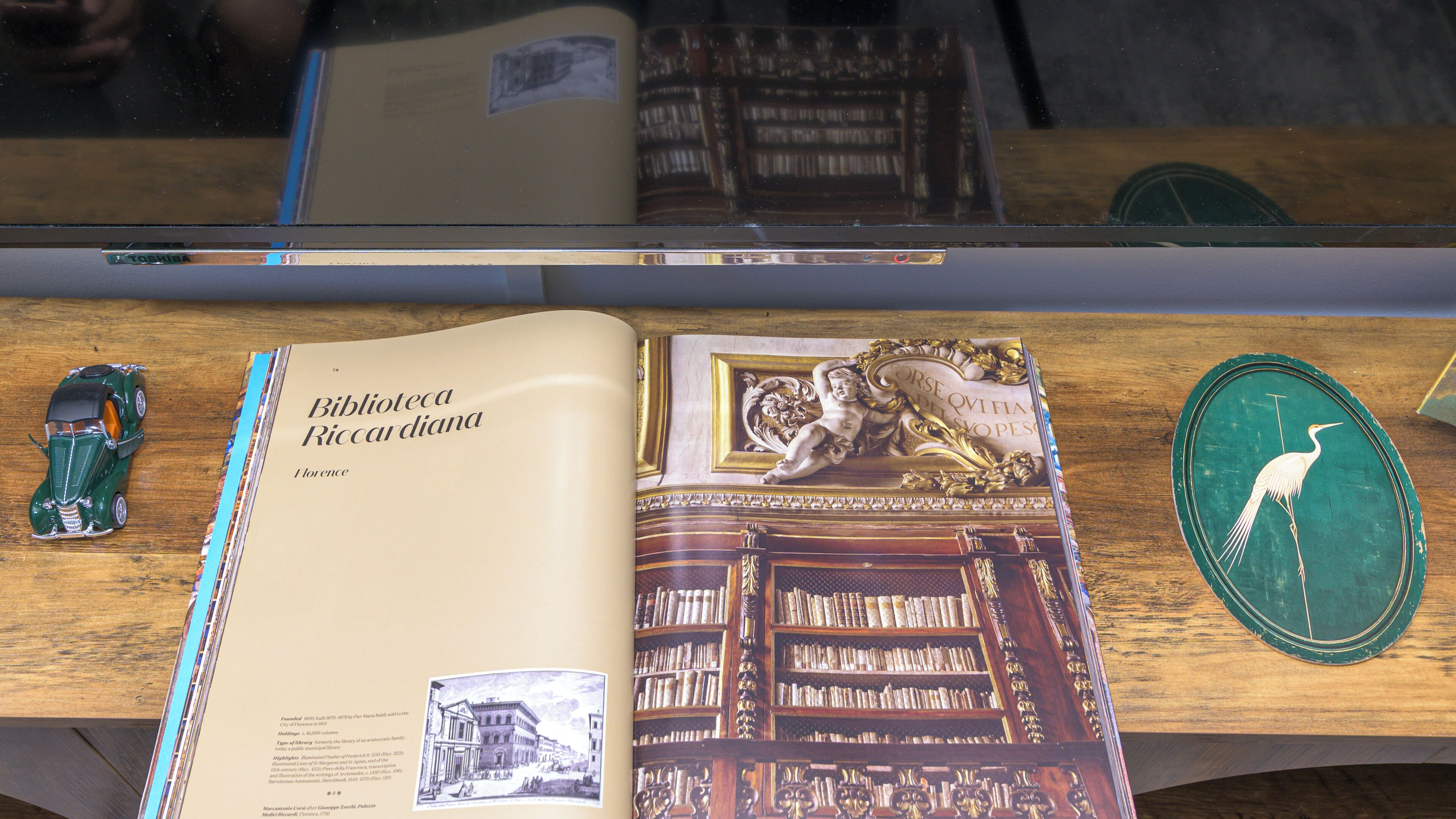 A book titled 'Biblioteca Riccardiana Florence' with a detailed illustration of a library interior.