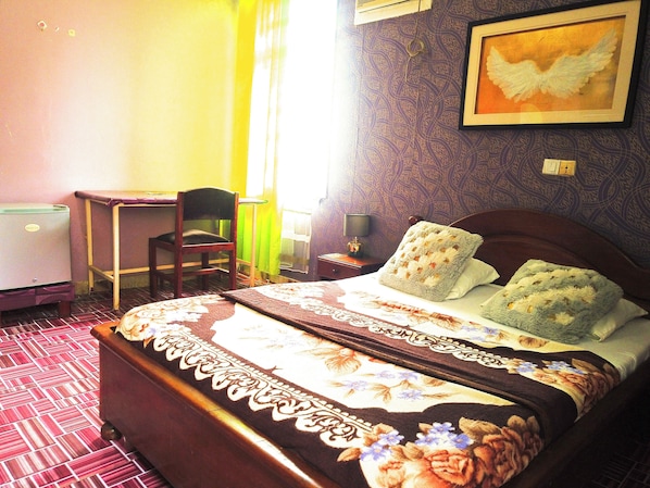 A hotel room with a bed, a desk, a chair, and a refrigerator. - Hôtel Belle Vue Yaounde (Yaoundé)