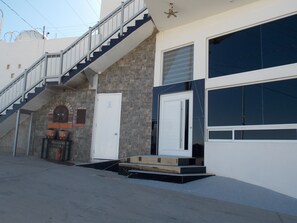 A residential building with a staircase, a garage door, and a stone wall. - Whale Hill Great View House (Puerto Peñasco)