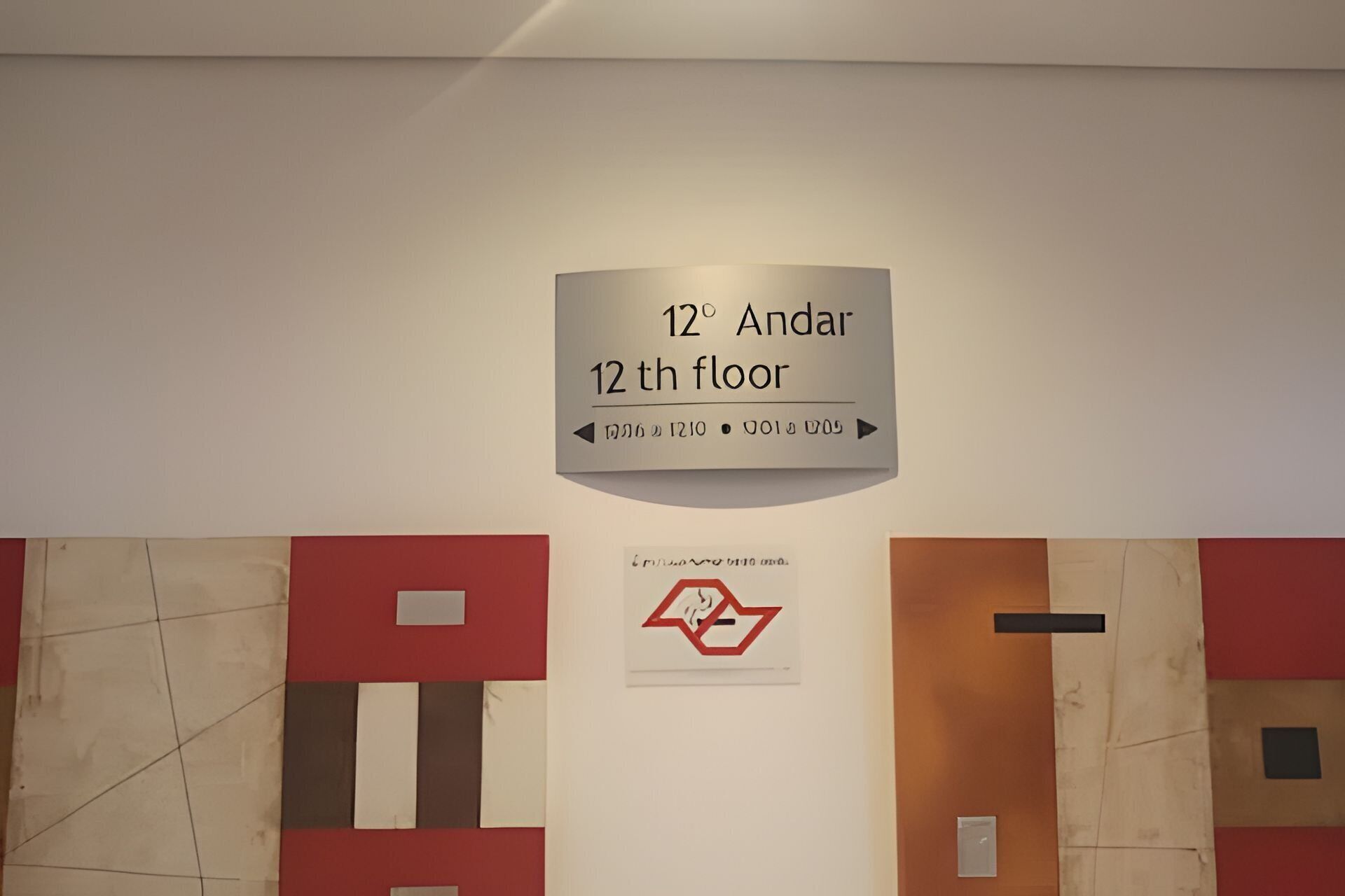 Ein Schild, das die 12. Etage mit Pfeilen und einem Symbol für den Aufzug zur 12. Etage anzeigt.