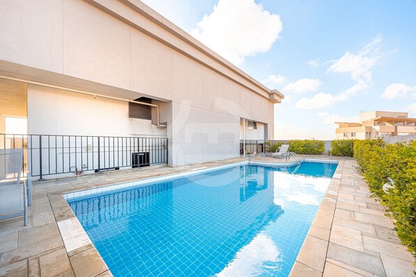 A modern building with a swimming pool, a covered area, and a clear sky. - Osasco Trade Fundação (Osasco)