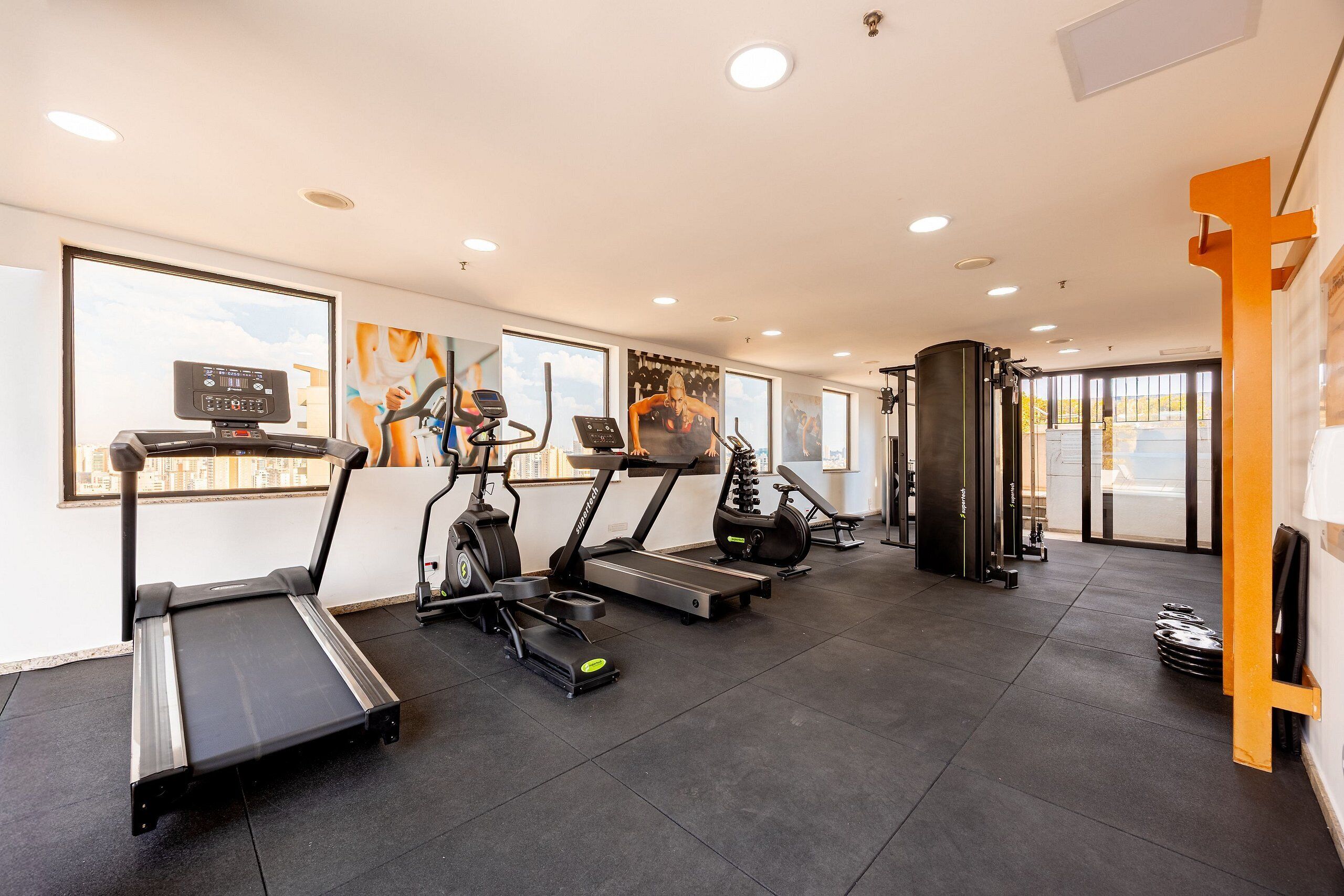 A gym with treadmills, elliptical machines, and weight equipment.