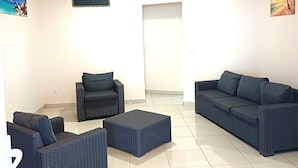 Ein Wohnzimmer mit einer Sofagarnitur, einem Sessel und einem Couchtisch.