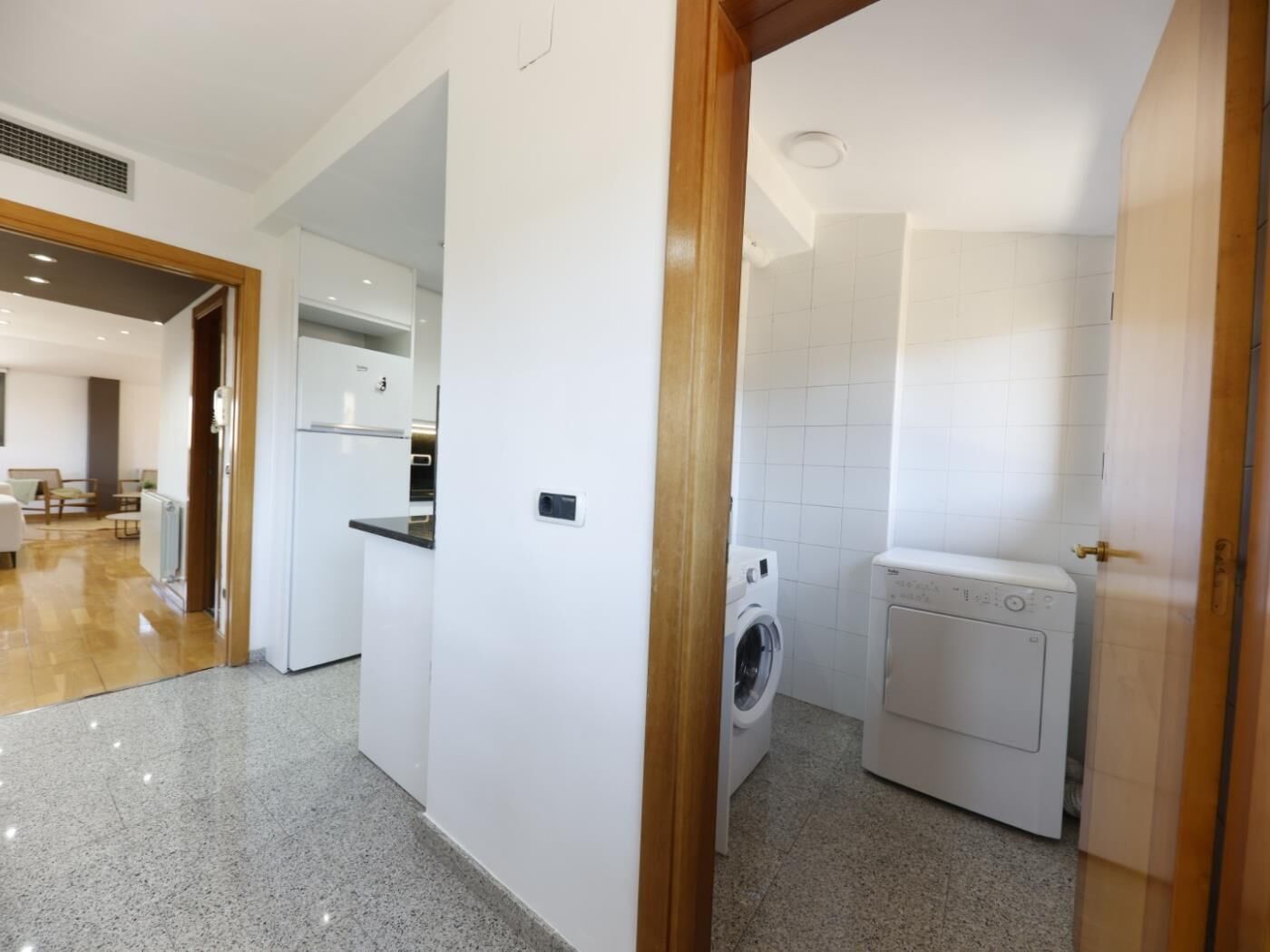Eine moderne Küche mit Waschmaschine und kompaktem Kühlschrank.