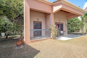 A two-story building with a covered patio area, a small garden, and a seating arrangement. - Villa 'Ariadni' in Marathiás (Marathiás)