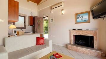 A living room with a sofa, a fireplace, a television, and a window.