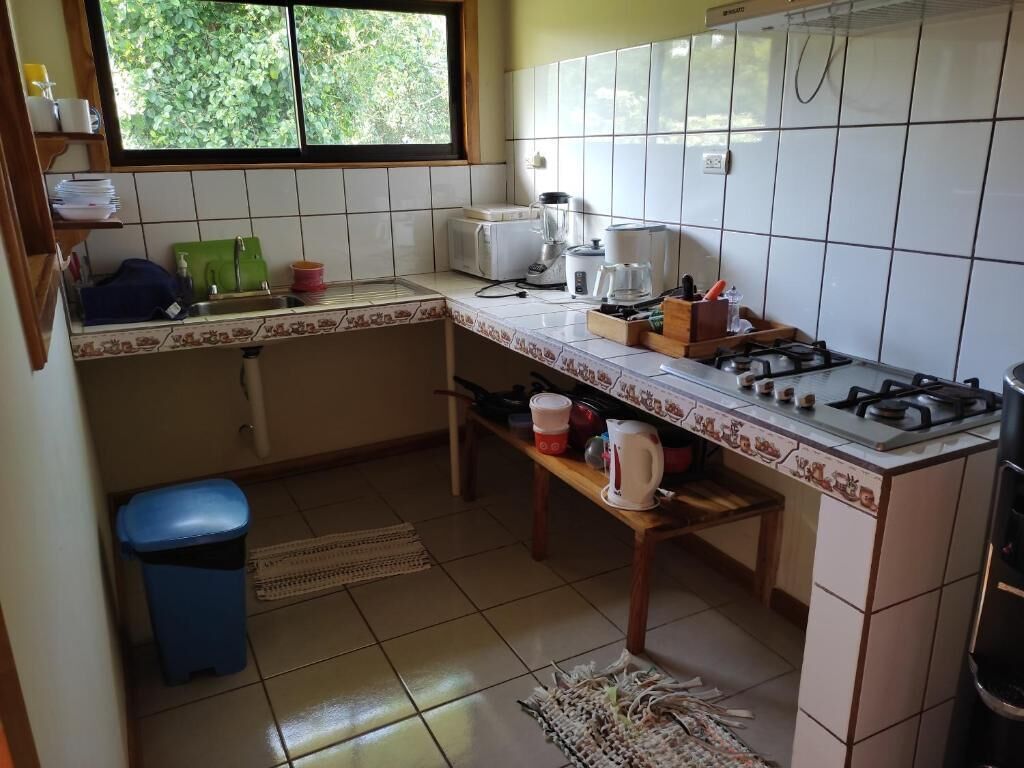 A compact kitchen with a gas stove, a coffee maker, and a toaster.