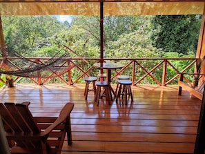 A wooden deck with a hammock, chairs, and a table. - Cecropia Wild Corcovado - Villa de 1 dormitorio 1 (Osa)