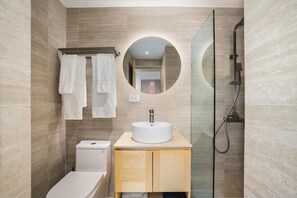 Ein modernes Badezimmer mit Toilette, Waschbecken und Dusche.