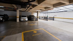 A multi-level parking garage with concrete floors, yellow parking lines, and a few parked cars. - Modern Studio in Chapinero | City Views & Workspace (Bogotá)