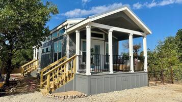 A two-story building with a covered porch and a wooden staircase.