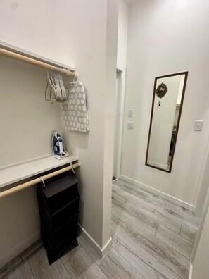 Une salle de bain avec un meuble-lavabo en bois, un miroir et un porte-serviettes.