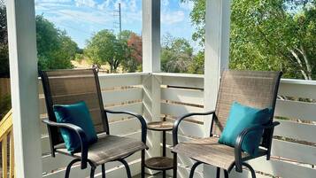 Un espace extérieur abrité, aménagé avec deux chaises et une petite table.