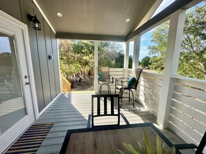 A covered outdoor area with a wooden deck, a table, and chairs.