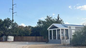 A small, single-story building with a metal roof and a covered porch area.