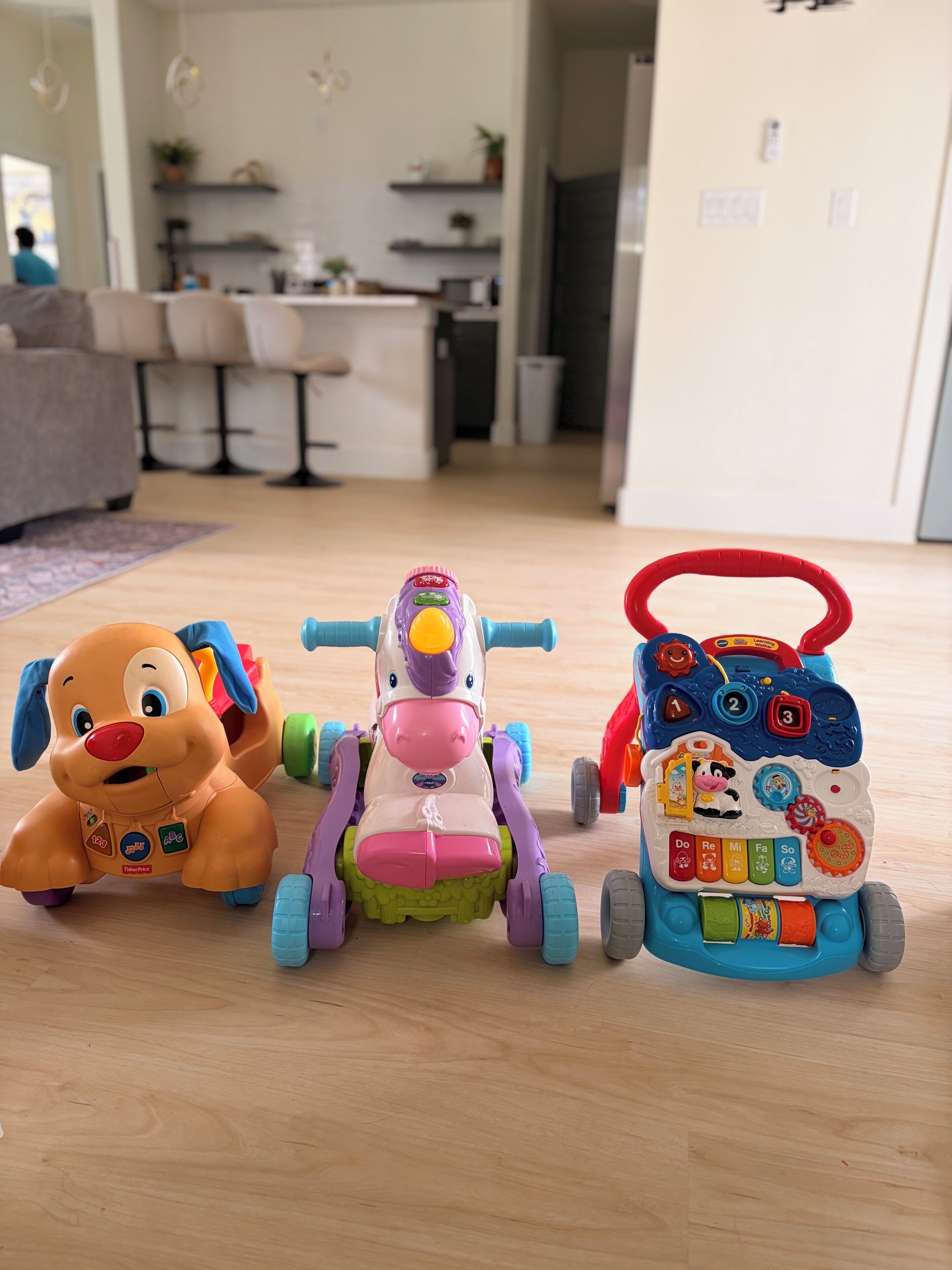 Three children's toys on a wooden floor.