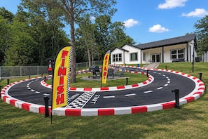 A racing track with a finish line and a start line, surrounded by grass and trees. - EPIC Fun: Game Room, New Lake View 3BD, RaceTrack! (Gun Barrel City)