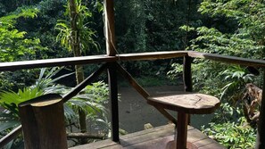 Eine Holzterrasse mit einer rustikalen Brüstung, die auf eine natürliche Landschaft blickt.