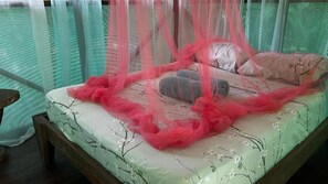 Un letto con baldacchino, cuscini e una testiera in legno.