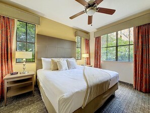 A hotel room with a bed, a nightstand, a ceiling fan, and large windows with curtains. - 3BR Orlando Resort | Heated Pools | 3 mi Disney (Orlando)