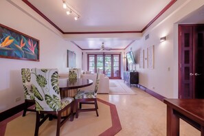 A spacious hallway with a dining area featuring a round table and chairs with a tropical leaf pattern upholstery. - Salty Breeze Suite|Seaview Family Residence w/Pool (San Pedro)