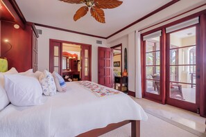 A bedroom with a large bed, a ceiling fan, and a view of the outdoors through a glass door. - Salty Breeze Suite|Seaview Family Residence w/Pool (San Pedro)