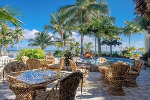 A poolside area with wicker furniture, a glass table, and a view of the ocean. - Salty Breeze Suite|Seaview Family Residence w/Pool (San Pedro)