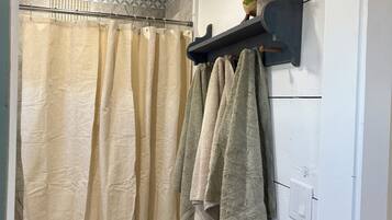 A bathroom with a shower curtain, a toilet, and towels hanging on a rack.