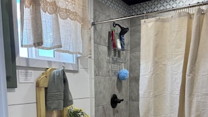 Un baño con inodoro, lavabo y zona de ducha.