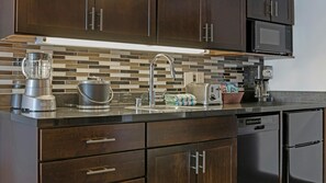 A kitchen with dark wood cabinets, a stainless steel countertop, a blender, a kettle, and a toaster. - Union Square San Francisco 1BR Deluxe Suite – Club Wyndham Canterbury (San Francisco)