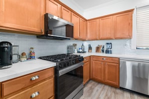 A modern kitchen with wooden cabinets, a stainless steel range, and a dishwasher. - Phoenix Luxe! Stylish Home! Pool & Hot Tub! Gated community (Phoenix)