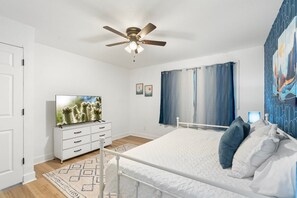 A bedroom with a bed, a ceiling fan, a TV, and a window with curtains. - The Desert Palm! Private Oasis! Heated Pool (Glendale)