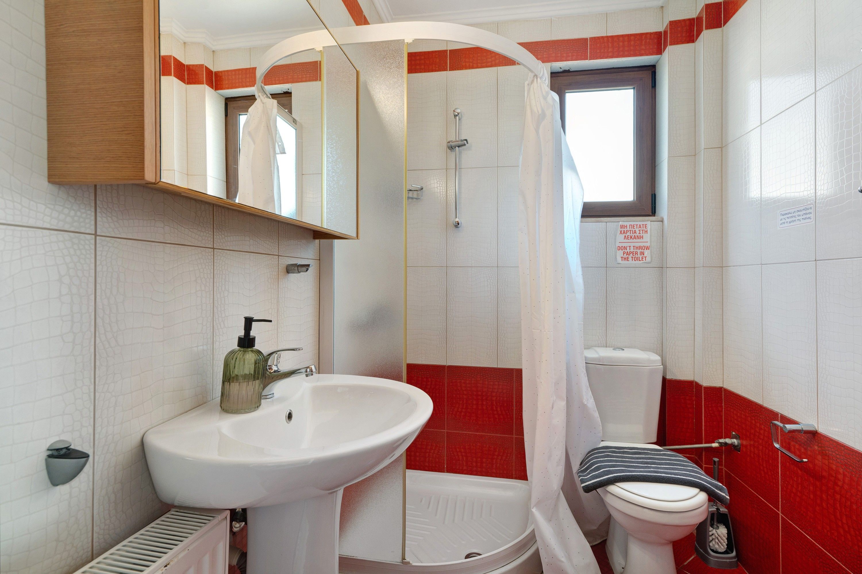 Ein Badezimmer mit Waschbecken, Toilette und Duschbereich.