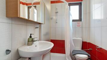 Ein Badezimmer mit Waschbecken, Toilette und Duschbereich.