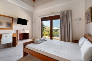 A bedroom with a bed, a desk, a television, and a fireplace. - Villa 'Kalirroe' in Marathiás (Marathiás)