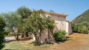 A single-story building with a tiled roof, a small porch, and a fire extinguisher mounted on the wall. - Villa 'Kalirroe' in Marathiás (Marathiás)