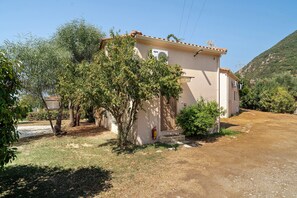 A single-story building with a tiled roof, a small porch, and a fire extinguisher mounted on the wall. - Villa 'Kalirroe' in Marathiás (Marathiás)